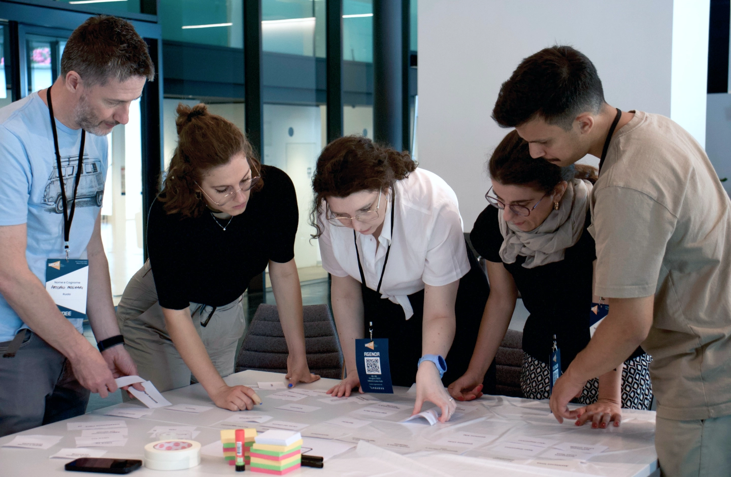 Immagine con persone intorno a un tavolo durante un workshop