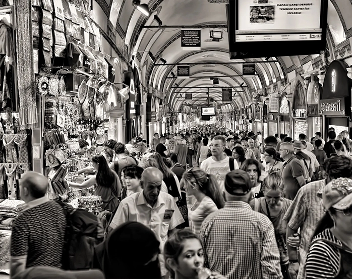 Fotografia in bianco e nero di una strada coperta affollata, simbolo di connessioni sociali e interazioni umane in un contesto urbano.